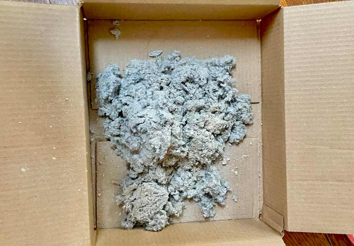 Hidden lint pulled from the cavity below a dryer lint trap